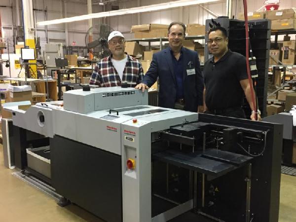From left: behind their new Horizon RD-4055DMC Rotary Die Cutter from KBR Graphics,&nbsp; Quentin Chan (Lead Hand, Lowe-Martin), Steve Klaric (, KBR Graphics)&nbsp; and Rob Castro (, Lowe-Martin).