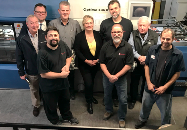First row: Rob Orfalian, Ellis Press Operator; Rob Levesque, Die-Cutting Lead Hand; and David Singh, Ellis Press Operator. Second row: Tom Fitzgerald, Koenig & Bauer product manager; Cathie Ellis, president of Ellis Packaging; and Mitch Spooner, Manager of Die-Cutting & Finishing Operations. Third row: Aleks Lajtman, Koenig & Bauer Regional Sales Manager, Canada; Don Smart, Ellis Plant Manager; and Joe Lang, Ellis Press Operator