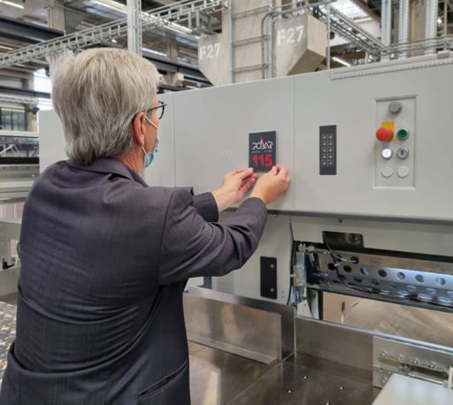 Marketing Manager Frank Mayer attaches the anniversary plaque to a cutting machine