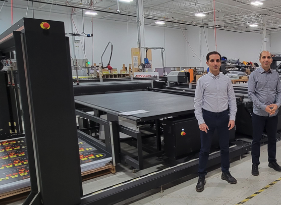 (From left) SinaLite Vice President Brian Meshkati and President Mike Meshkati with the Kongsberg C64 and Feeder & Stacker