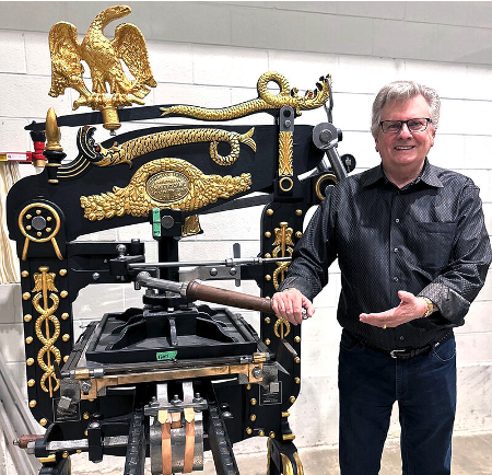 founder Robert E. Gilmore beside rebuilt Columbian iron press